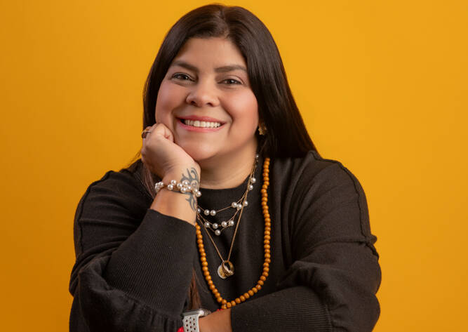 a headshot of a business owner with yellow background