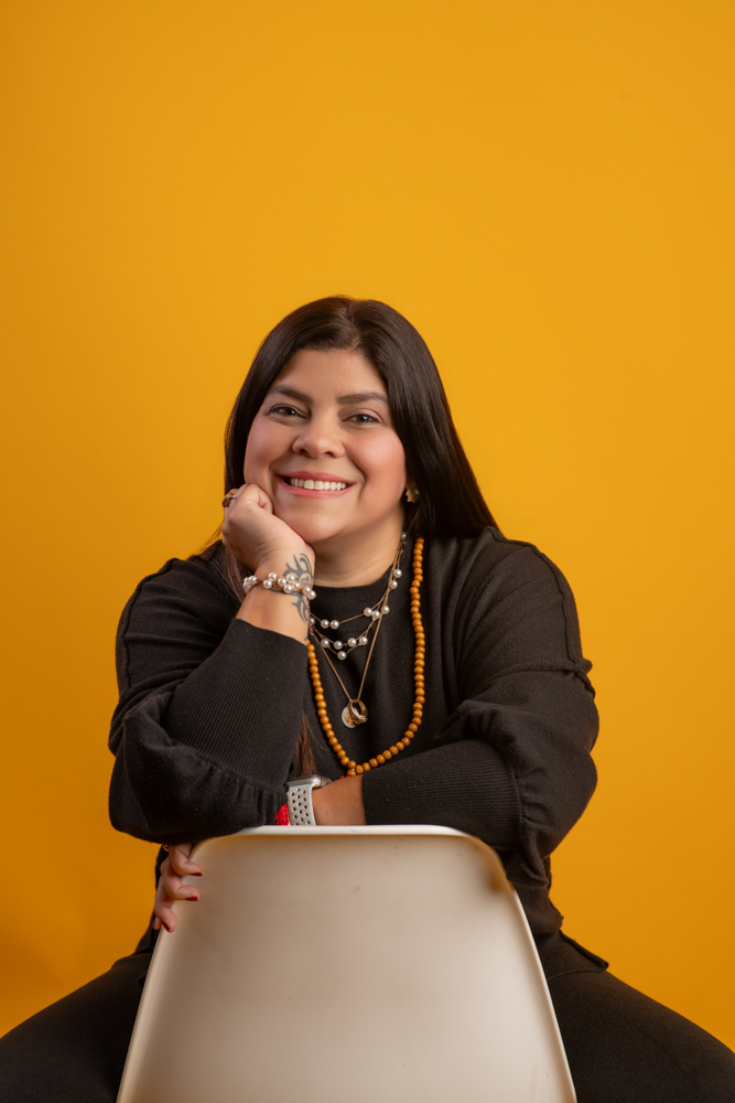 a headshot of a business owner with yellow background